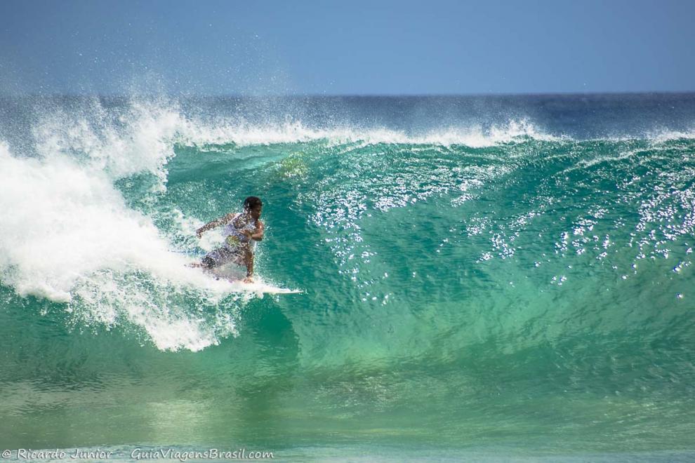 Imagem de um surfista rasgando no tubo.